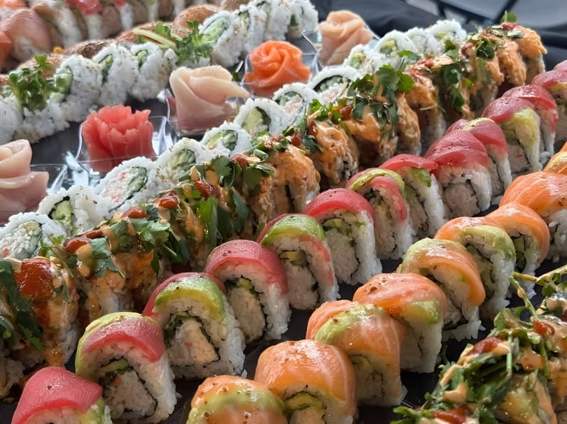 A vibrant platter showcases an array of sushi rolls, including salmon, tuna, and avocado.